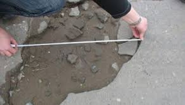 Патрульные полицейские измеряют ямы на дорогах в Донецкой области